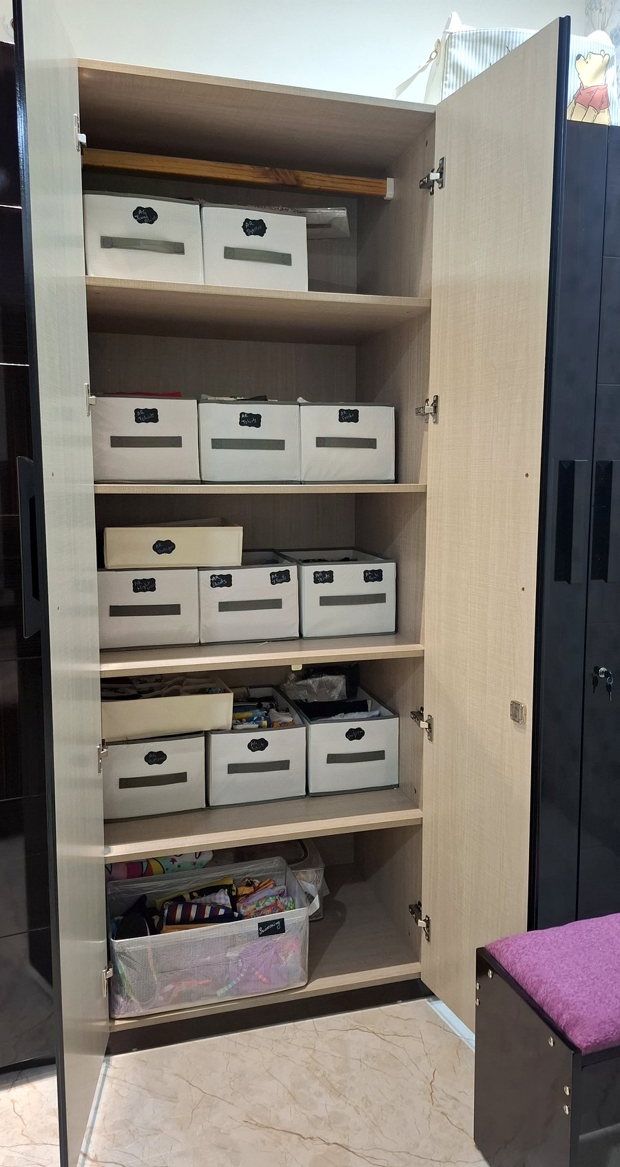 Kids wardrobe after professional organizing — labeled white fabric bins by category, file-folded contents, Scheme No. 140 Indore